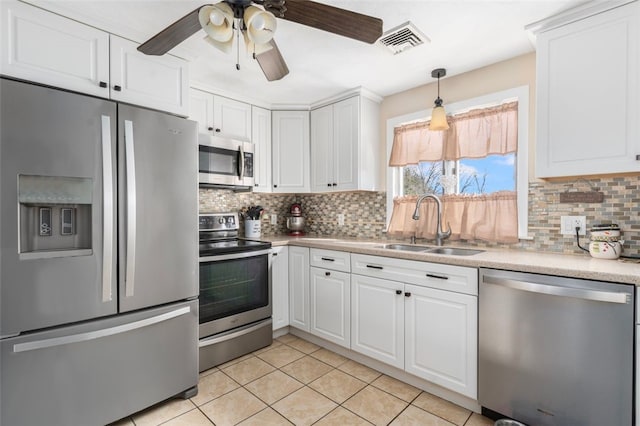 kitchen with visible vents, light countertops, white cabinets, stainless steel appliances, and a sink