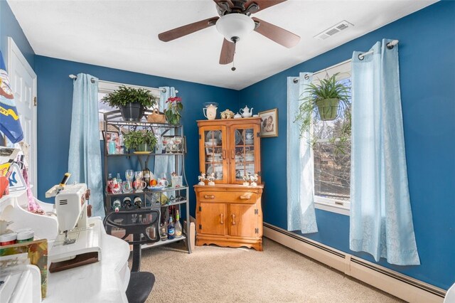 interior space with baseboard heating, a ceiling fan, visible vents, and carpet floors