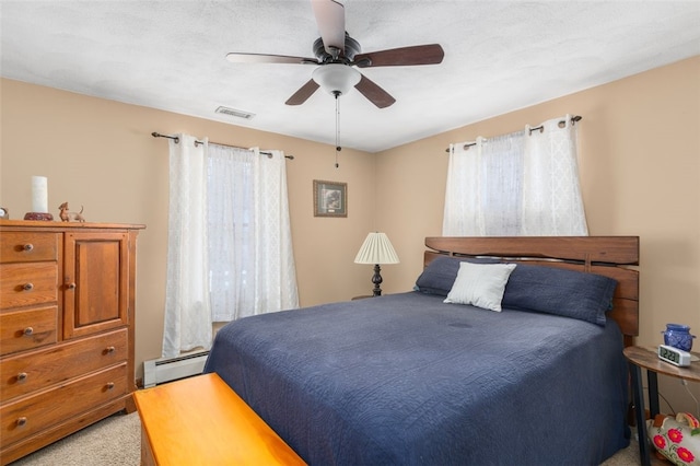 bedroom featuring ceiling fan, light carpet, visible vents, and a baseboard radiator