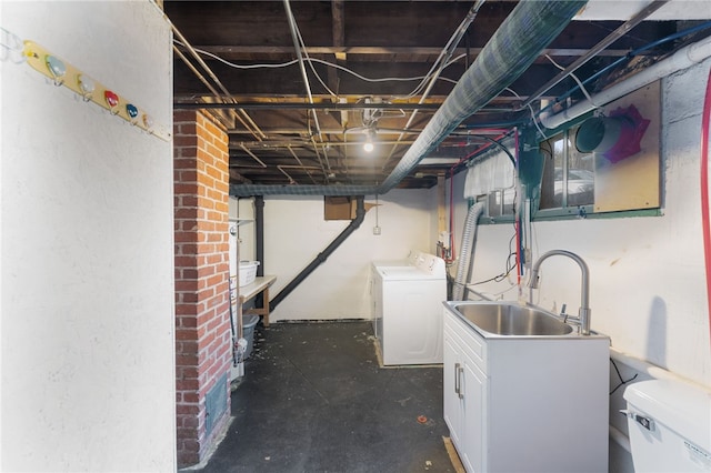 unfinished basement with a sink and washing machine and clothes dryer