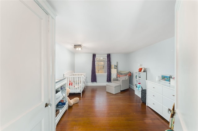 bedroom featuring baseboards and dark wood-style flooring