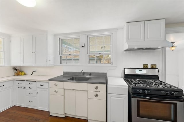 kitchen featuring stainless steel gas range oven, white cabinets, and a sink