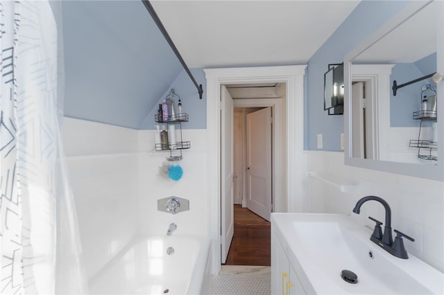 full bathroom with vanity, lofted ceiling, and shower / tub combo with curtain