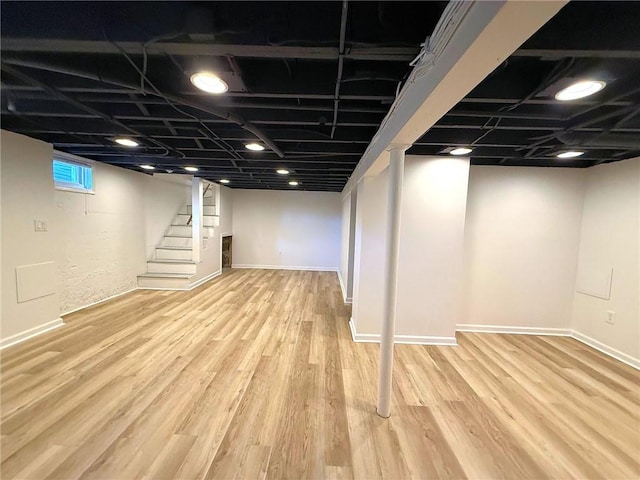 basement with stairway, baseboards, and wood finished floors