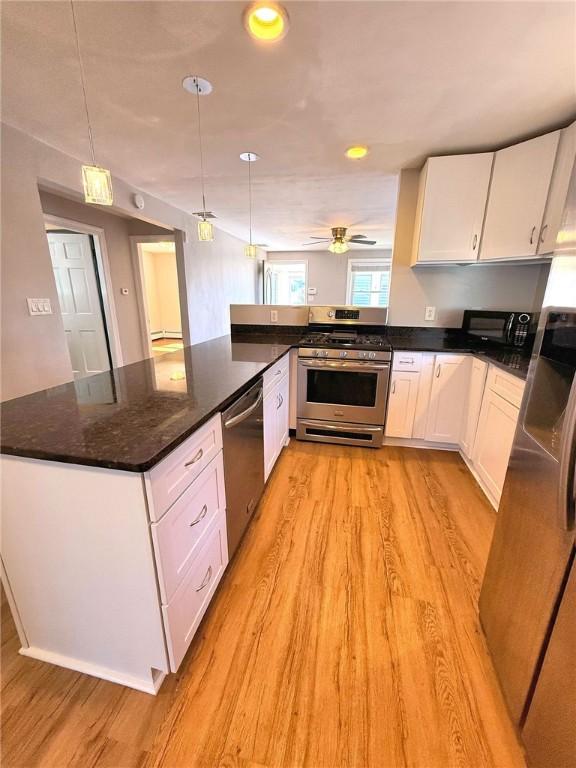 kitchen featuring light wood-style flooring, appliances with stainless steel finishes, and white cabinetry