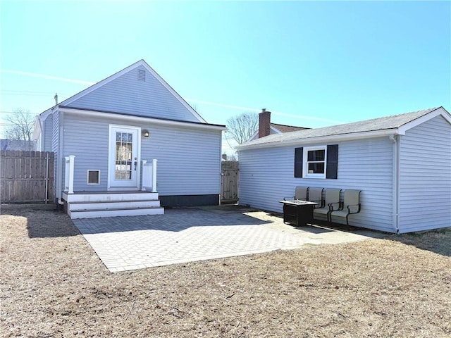 back of property with a patio, fence, and a chimney