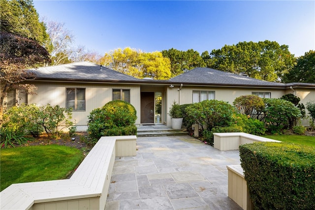 ranch-style house featuring a front yard and a patio