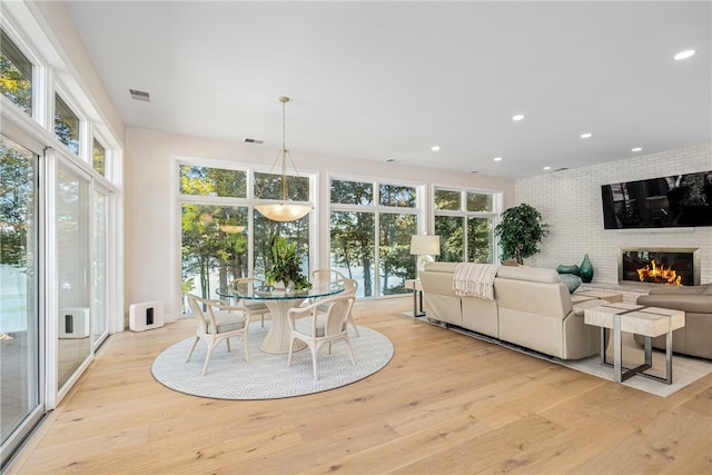 interior space featuring visible vents, plenty of natural light, light wood-style floors, and a fireplace