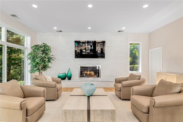 living area featuring plenty of natural light, a fireplace, and visible vents