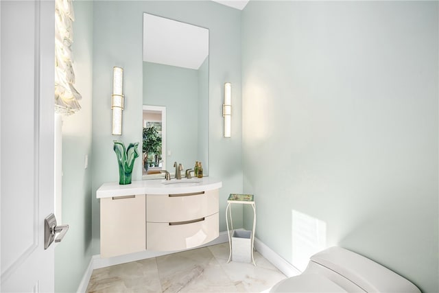 bathroom with baseboards, toilet, and vanity