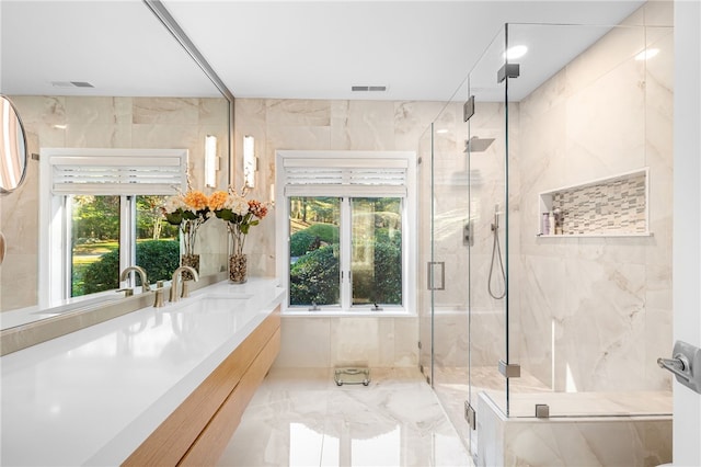 full bath featuring vanity, tile walls, marble finish floor, and a marble finish shower