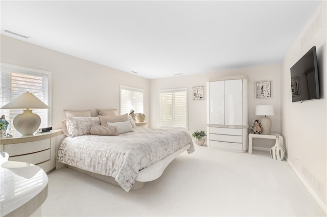 carpeted bedroom featuring visible vents