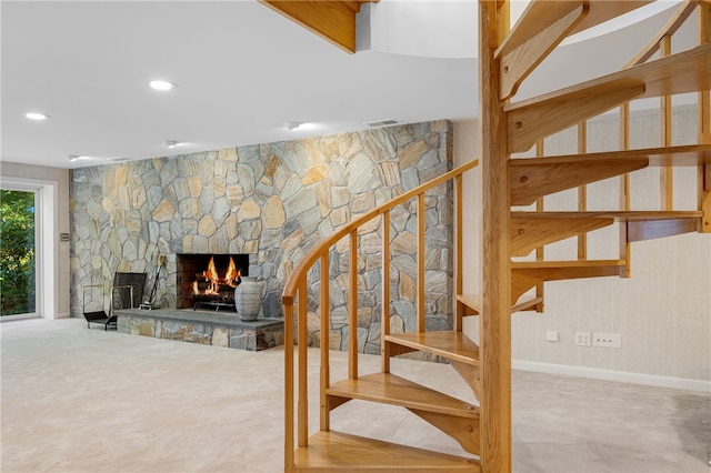 stairway with a stone fireplace, recessed lighting, visible vents, and baseboards