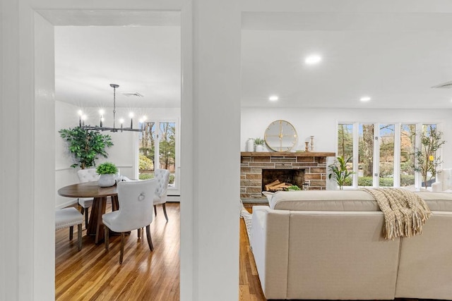 living area featuring recessed lighting, plenty of natural light, wood finished floors, and a fireplace