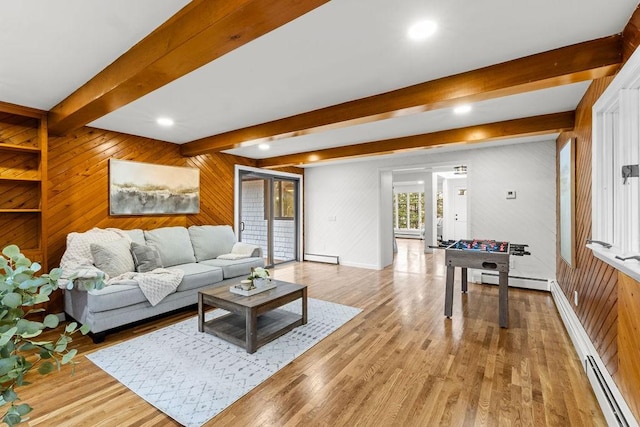 living area with baseboard heating, beamed ceiling, and light wood-type flooring