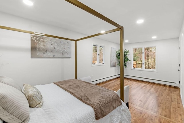 bedroom with recessed lighting, a baseboard radiator, and wood finished floors