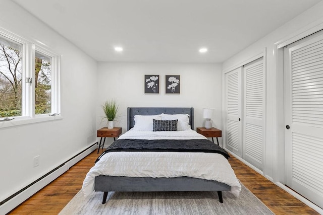 bedroom with recessed lighting, wood finished floors, and a baseboard radiator