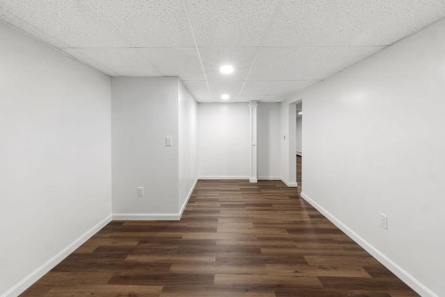 interior space featuring recessed lighting, a paneled ceiling, baseboards, and wood finished floors