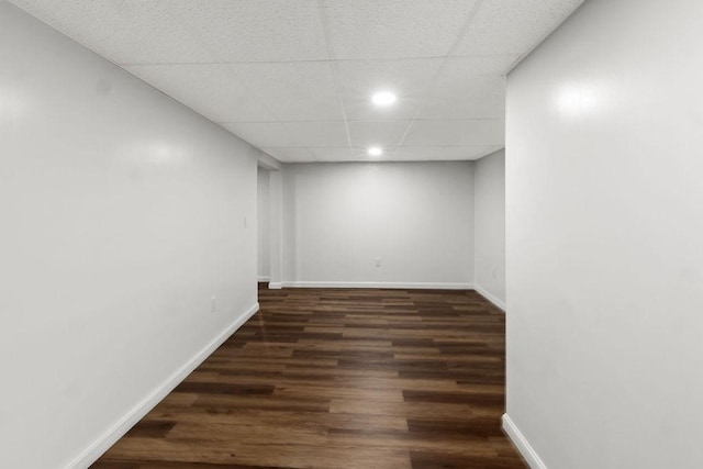 finished basement with recessed lighting, a paneled ceiling, baseboards, and wood finished floors