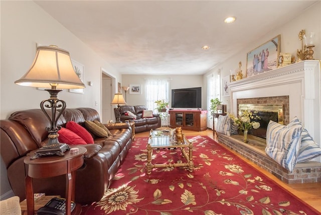 living room with wood finished floors and a tile fireplace