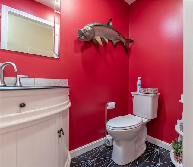 bathroom featuring baseboards, toilet, vanity, and tile patterned flooring