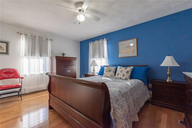 bedroom with light wood-style flooring and a ceiling fan