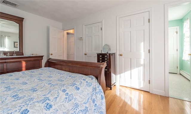 bedroom with visible vents, light wood-style flooring, and multiple windows