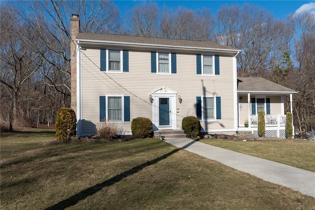 colonial home with a front lawn and a chimney