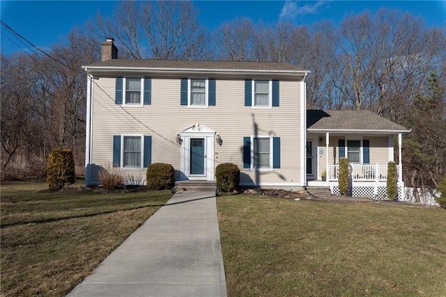 colonial-style house with a porch, a chimney, and a front lawn