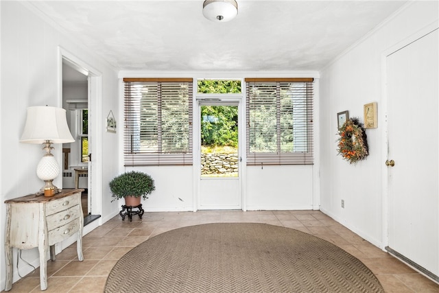 doorway to outside with baseboards, plenty of natural light, and tile patterned flooring