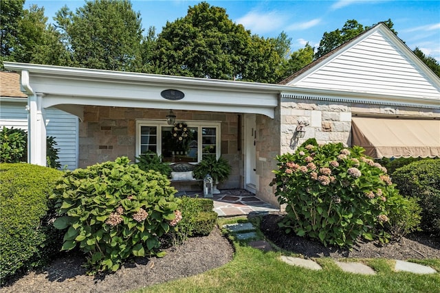 view of front of house with stone siding and covered porch