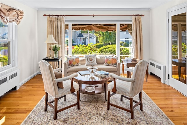 interior space featuring crown molding, radiator, and light wood finished floors