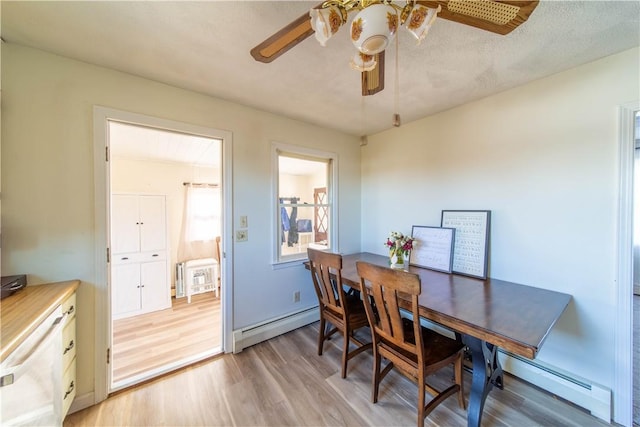 dining room featuring a baseboard heating unit, light wood-style floors, and ceiling fan