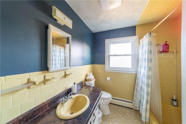 bathroom featuring vanity, a textured ceiling, a baseboard heating unit, tile walls, and toilet