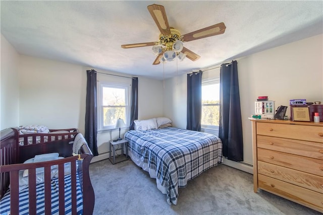 carpeted bedroom featuring a baseboard radiator and ceiling fan