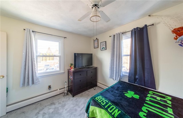 bedroom featuring carpet floors, baseboard heating, and a ceiling fan