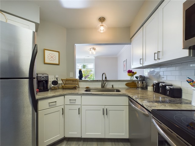 kitchen with white cabinets, tasteful backsplash, appliances with stainless steel finishes, and a sink