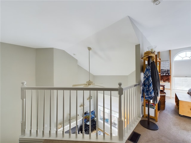 hallway featuring vaulted ceiling, an upstairs landing, carpet, and visible vents