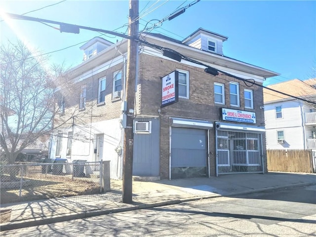 view of front of house with a garage, fence, and brick siding