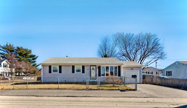 single story home with a fenced front yard, a garage, and driveway