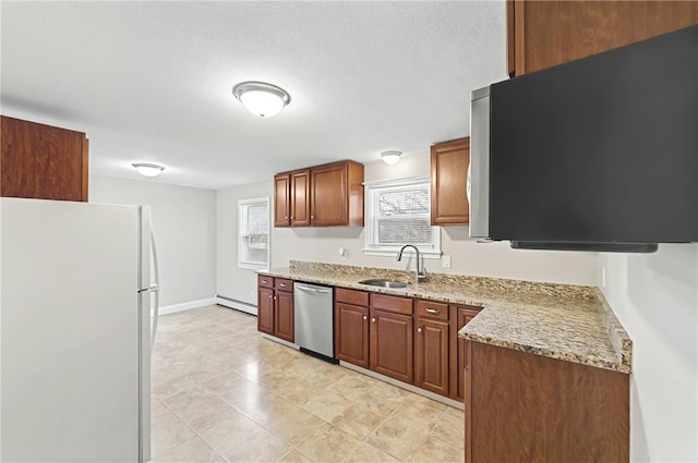 kitchen with brown cabinets, a sink, light stone counters, stainless steel appliances, and a baseboard radiator