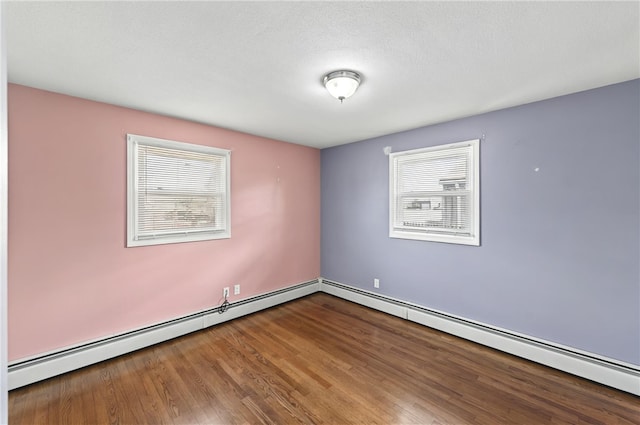 unfurnished room featuring a baseboard radiator and wood finished floors