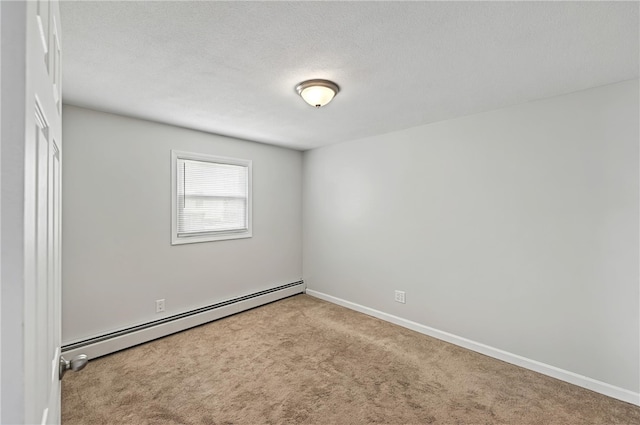 empty room featuring a textured ceiling, a baseboard heating unit, baseboards, and carpet floors