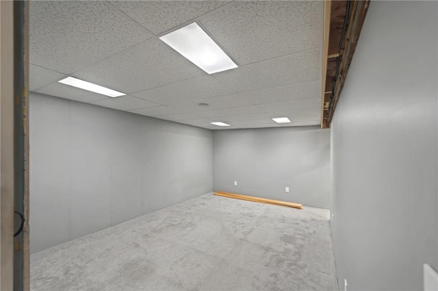 finished basement featuring a paneled ceiling and carpet floors