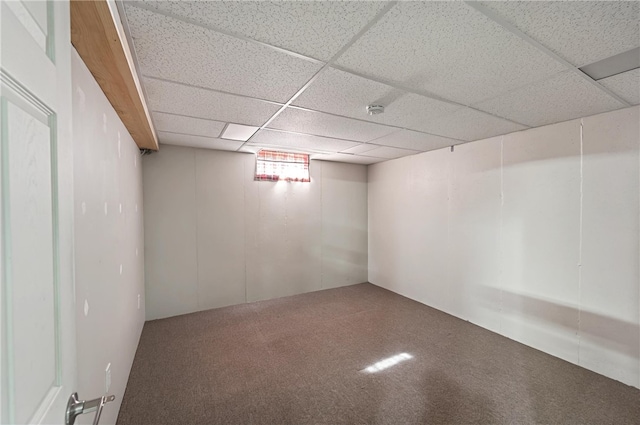 below grade area with a paneled ceiling and carpet