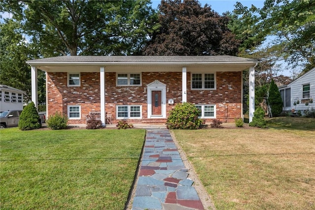 split foyer home featuring brick siding and a front yard