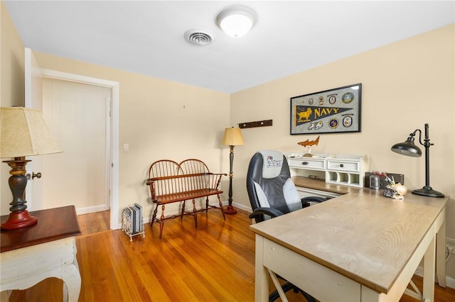 office area with visible vents, baseboards, and wood finished floors