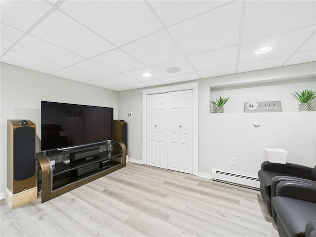 living room with baseboards, recessed lighting, wood finished floors, a paneled ceiling, and a baseboard radiator