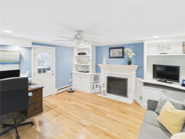 living room featuring a fireplace with flush hearth, built in features, light wood finished floors, baseboard heating, and ceiling fan