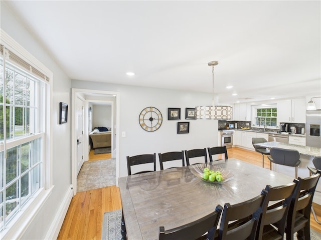 dining room featuring recessed lighting, baseboards, and light wood finished floors